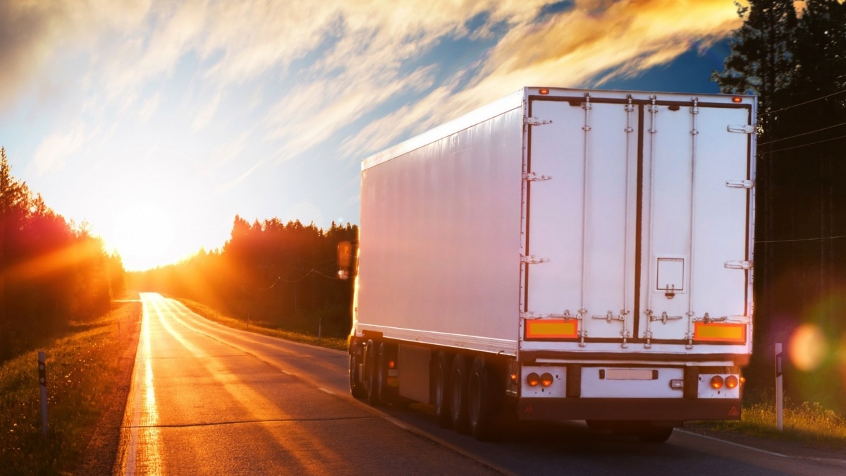 Truck on road as sunrises