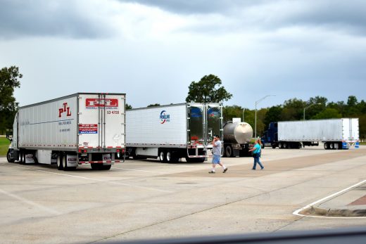 Truck Driver walking to truck at highway rest-stop, truck parking