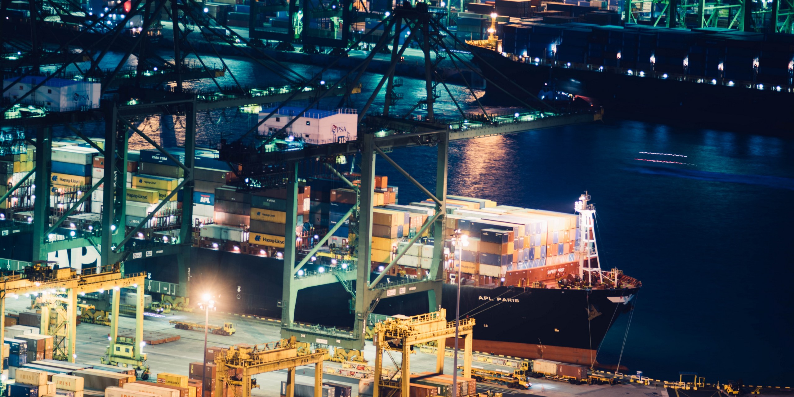 Photo of port with cargo ship picking up and offloading cargo