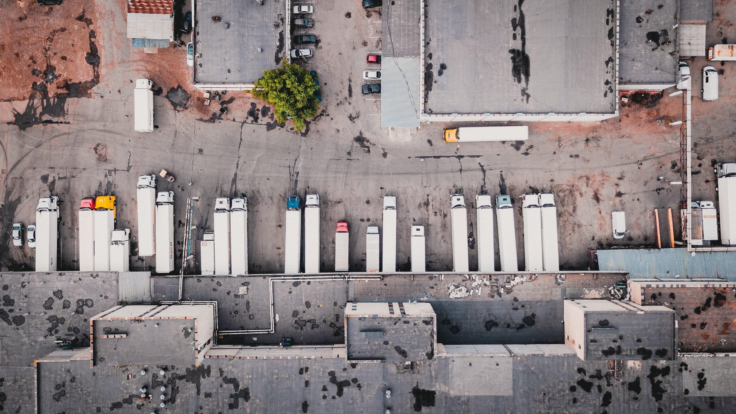 aerial view of trucks on gray commercial building during daytime photo, Photo by Ivan Bandura on Unsplash