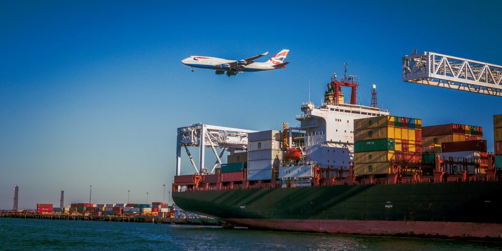 Airlines Plane flying over Cargo Ship at Port, Photo by VanveenJF on Unsplash, Congress Passes Historic Infrastructure Package